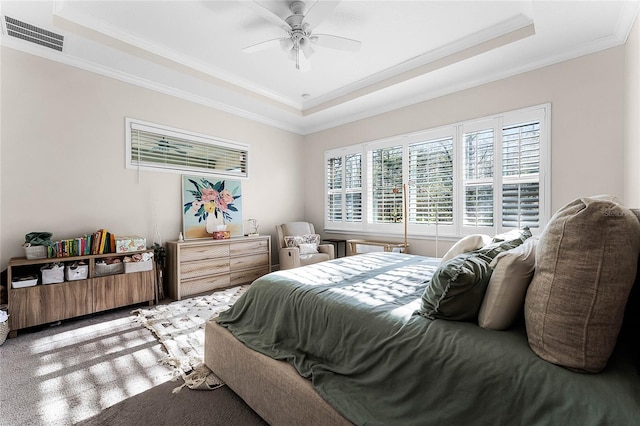 bedroom featuring visible vents, a raised ceiling, a ceiling fan, and ornamental molding