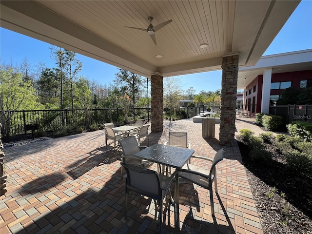 view of patio featuring outdoor dining space, ceiling fan, and fence