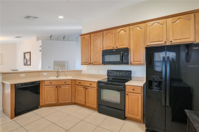 kitchen featuring visible vents, black appliances, a sink, a peninsula, and light countertops