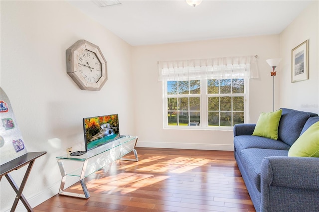 living area with baseboards and wood-type flooring