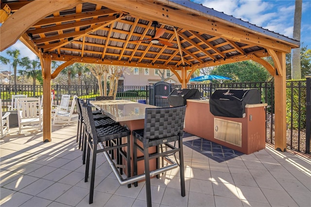 view of patio featuring a gazebo, grilling area, outdoor dining space, and fence