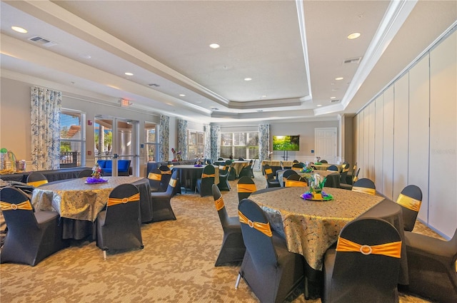 dining space featuring visible vents, a raised ceiling, and crown molding