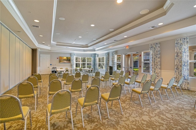 dining space with a tray ceiling, carpet, visible vents, and ornamental molding