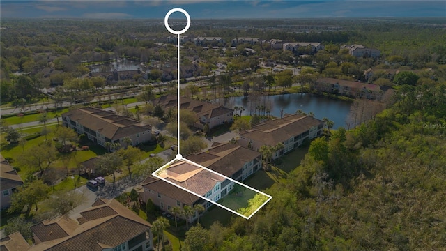 drone / aerial view featuring a forest view, a water view, and a residential view