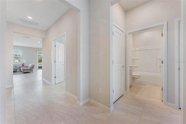 hall with recessed lighting, visible vents, and baseboards