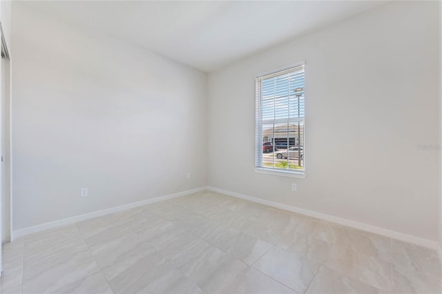 unfurnished room featuring baseboards