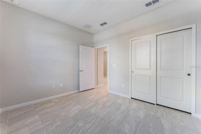 unfurnished bedroom with visible vents, baseboards, and a closet