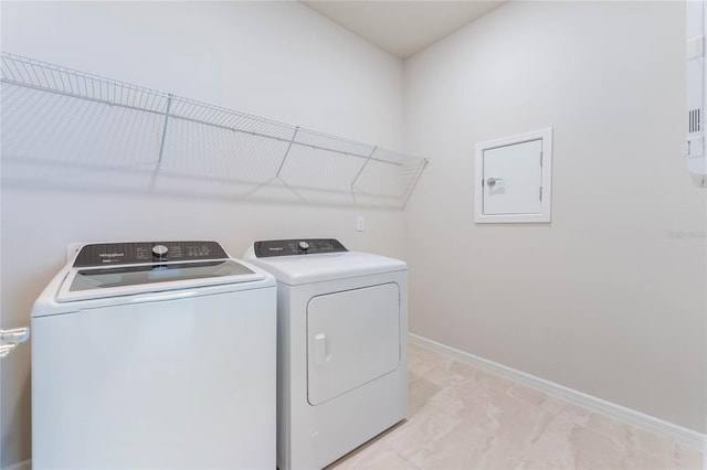 clothes washing area with laundry area, baseboards, and separate washer and dryer