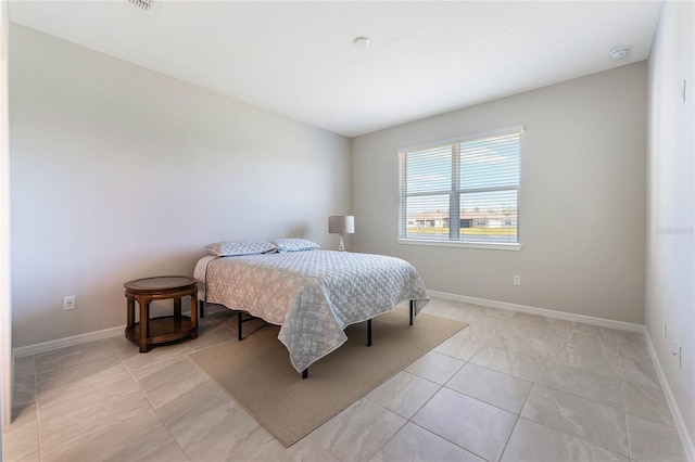 bedroom with light tile patterned flooring and baseboards