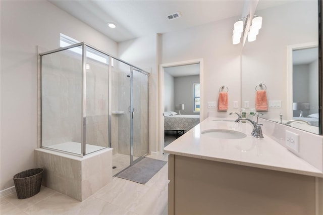 ensuite bathroom with a sink, a shower stall, visible vents, and connected bathroom