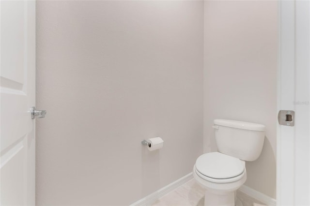 bathroom with tile patterned floors, baseboards, and toilet