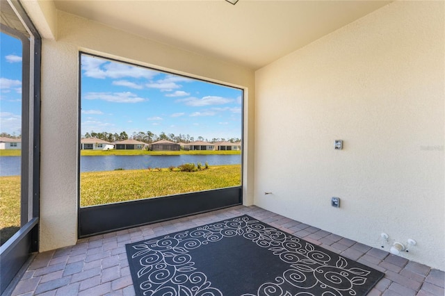 unfurnished sunroom featuring a water view and lofted ceiling