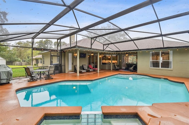 view of swimming pool with grilling area, a pool with connected hot tub, a ceiling fan, and a patio