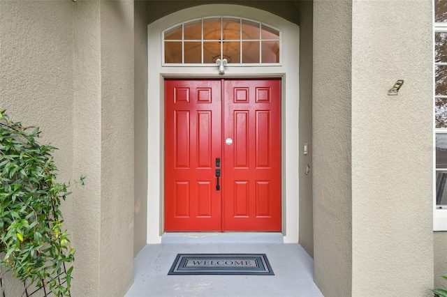 view of exterior entry featuring stucco siding