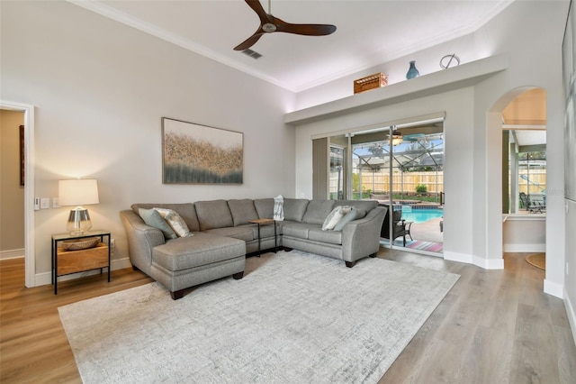 living area featuring visible vents, crown molding, ceiling fan, a sunroom, and wood finished floors