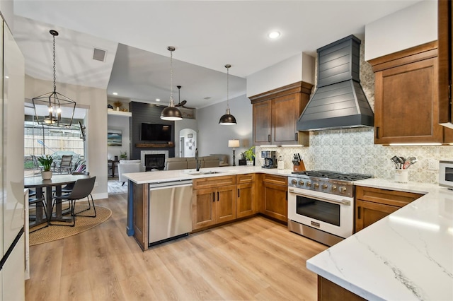 kitchen with visible vents, a sink, stainless steel appliances, a peninsula, and custom exhaust hood