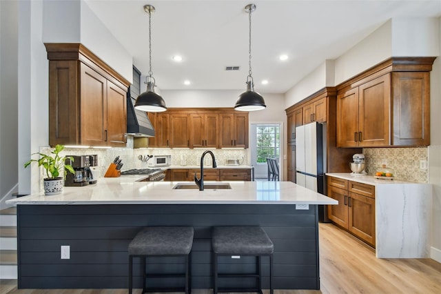 kitchen with a breakfast bar, a sink, freestanding refrigerator, a peninsula, and white microwave