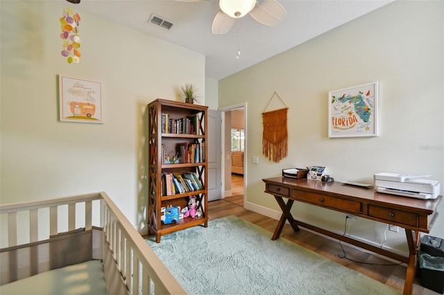 office featuring ceiling fan, wood finished floors, visible vents, and baseboards