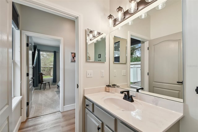 bathroom featuring baseboards, wood finished floors, and vanity