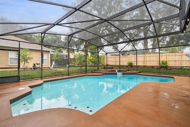 view of pool with a lanai, a pool with connected hot tub, a patio, and fence