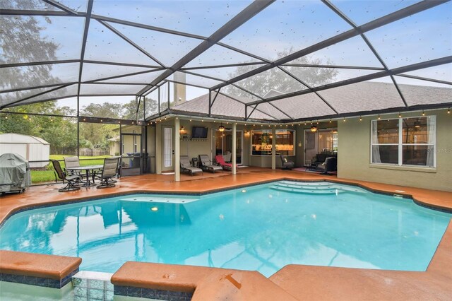 view of pool featuring a pool with connected hot tub, a storage shed, a patio area, an outbuilding, and a ceiling fan