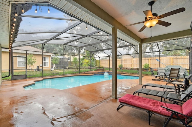 view of swimming pool with glass enclosure, a ceiling fan, a fenced in pool, a fenced backyard, and a patio area