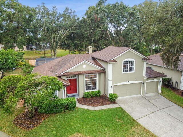 view of front of property featuring concrete driveway, a front yard, stucco siding, a chimney, and a garage