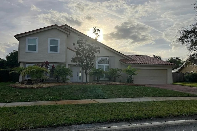 view of front of house with a garage, stucco siding, concrete driveway, and a front yard