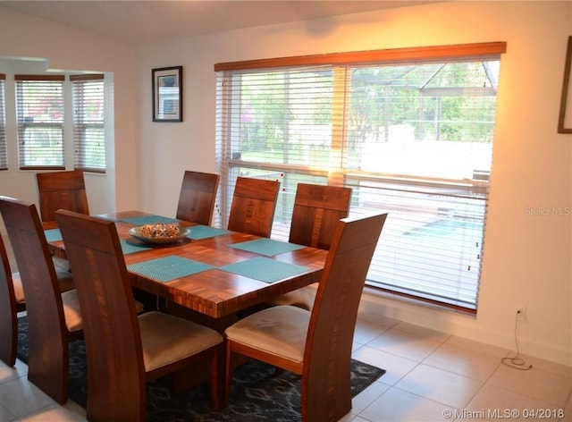 tiled dining space featuring lofted ceiling