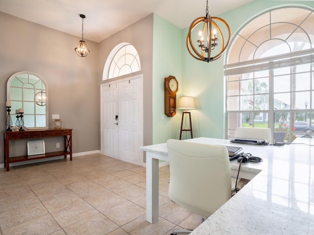 foyer with a chandelier, baseboards, and a towering ceiling