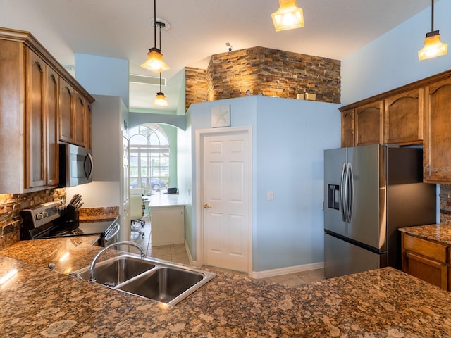 kitchen featuring dark countertops, hanging light fixtures, appliances with stainless steel finishes, and a sink