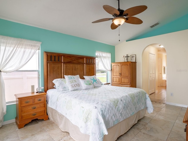 bedroom with visible vents, ceiling fan, baseboards, vaulted ceiling, and arched walkways