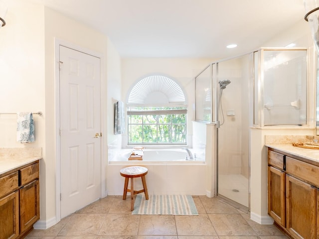 bathroom with tile patterned flooring, a stall shower, vanity, and a bath