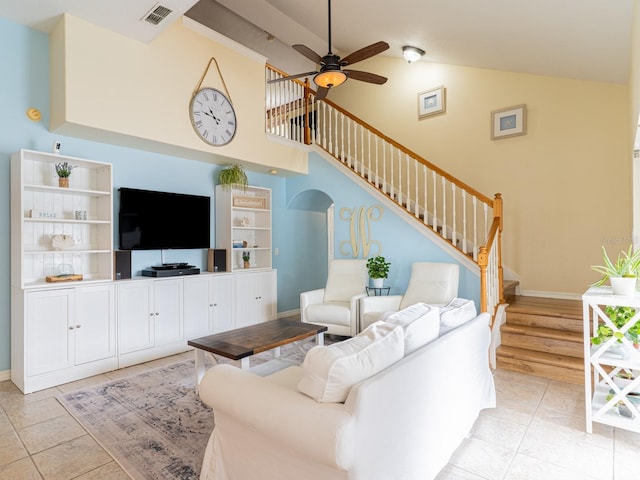 living area featuring light tile patterned floors, visible vents, stairs, and ceiling fan