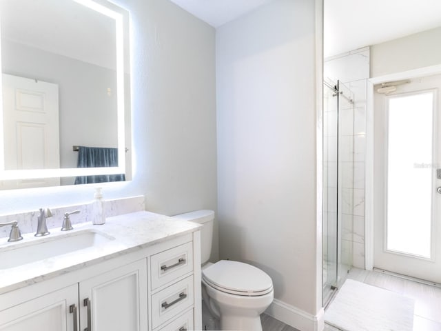 full bathroom with baseboards, toilet, a stall shower, and vanity