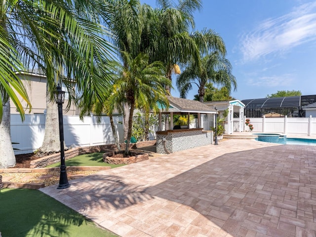 exterior space with a patio area, a fenced in pool, outdoor dry bar, and a fenced backyard