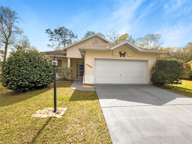 single story home with a front yard, a garage, driveway, and stucco siding