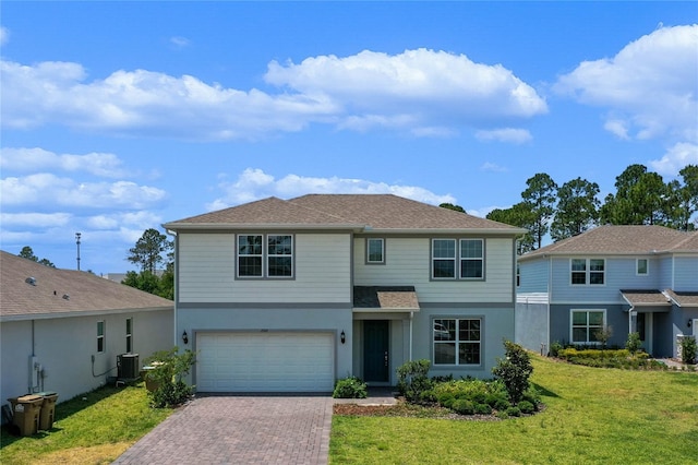 traditional-style home with central AC, a front yard, stucco siding, a garage, and driveway