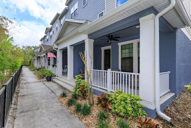 view of home's exterior with stucco siding, a porch, ceiling fan, and fence