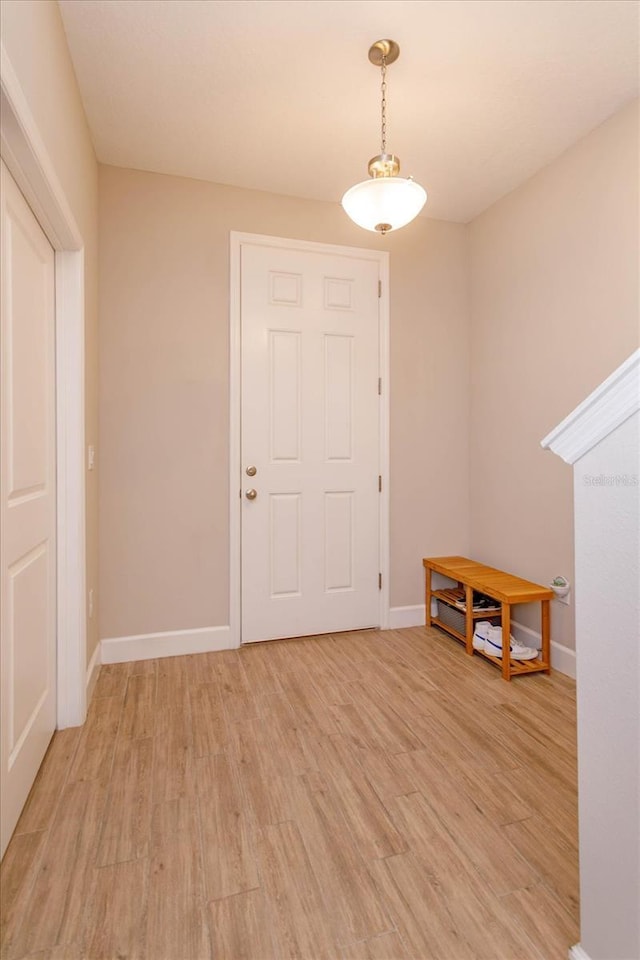 foyer featuring baseboards and light wood finished floors