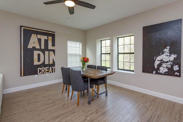 dining room with wood finished floors, baseboards, and ceiling fan