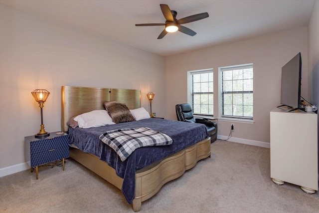 bedroom featuring baseboards, light colored carpet, and ceiling fan