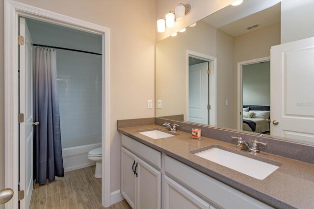 full bath with double vanity, connected bathroom, visible vents, and a sink