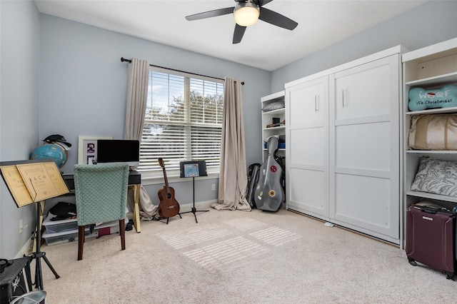 home office with a ceiling fan, light colored carpet, and baseboards