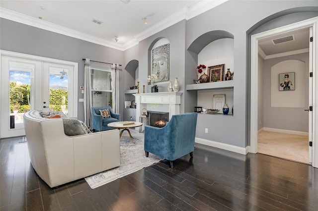 living area featuring dark wood finished floors, visible vents, a warm lit fireplace, and ornamental molding