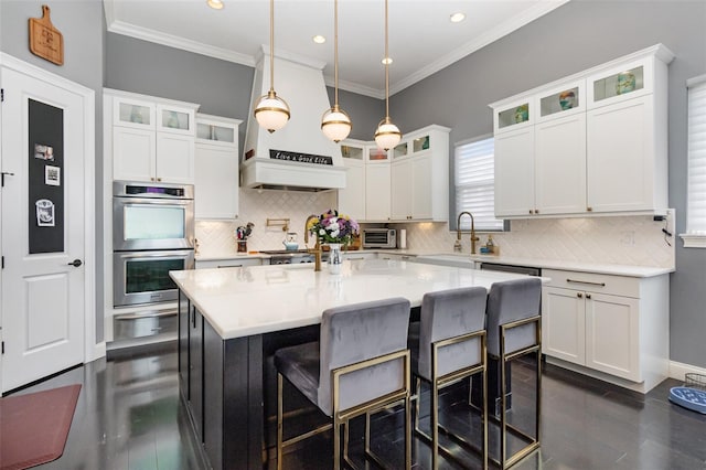 kitchen featuring a sink, white cabinets, a breakfast bar area, and stainless steel appliances