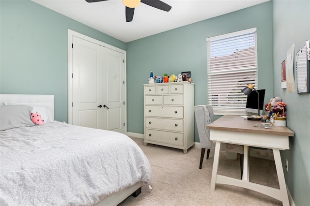 bedroom with a ceiling fan, light colored carpet, baseboards, and a closet