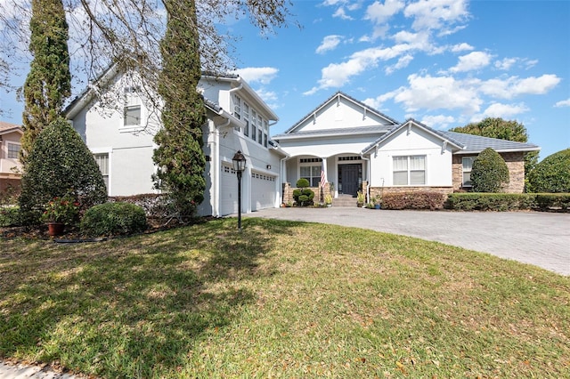 view of front of house with stucco siding, a front lawn, an attached garage, and driveway