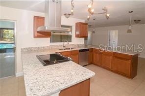 kitchen featuring stainless steel dishwasher, a peninsula, and brown cabinets