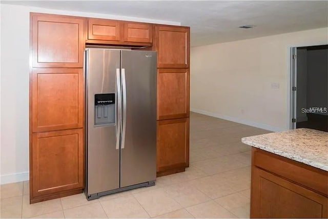 100 Huntswood Ct, Longwood, FL 32750 - kitchen with stainless steel fridge, light stone countertops, brown cabinets, and light tile patterned flooring